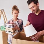 a young couple packing for a budget-friendly move to Coral Gables