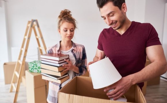 a young couple packing for a budget-friendly move to Coral Gables