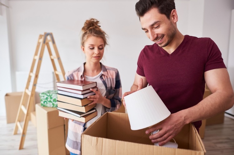 a young couple packing for a budget-friendly move to Coral Gables